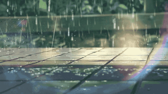 rain is falling on a tiled floor and a rainbow is visible