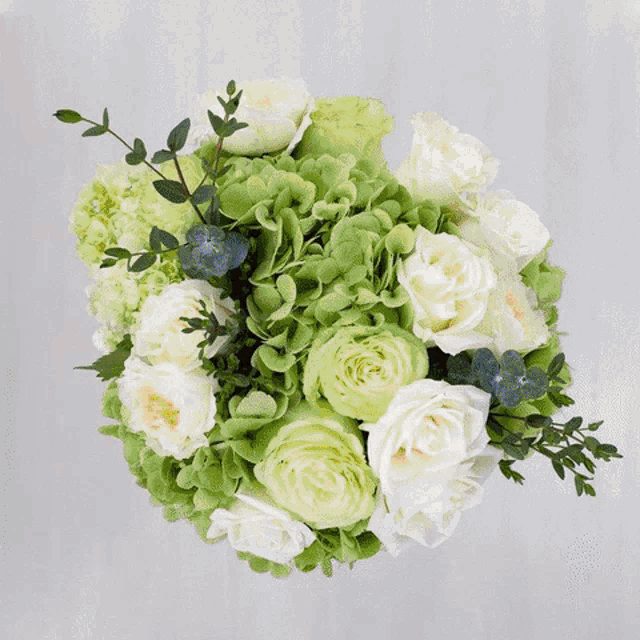 a white vase filled with flowers and greenery