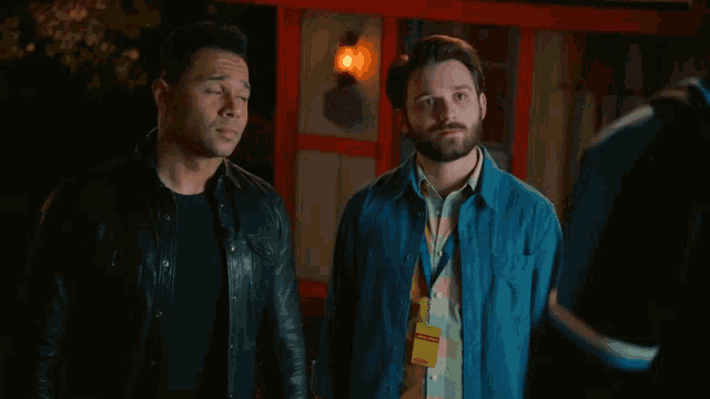 two men are standing next to each other and one of them has a yellow lanyard that says ' emergency ' on it