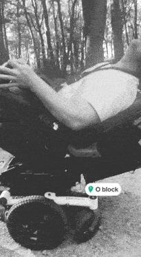 a black and white photo of a person in a wheelchair with the word o block on the bottom right