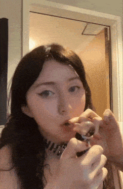 a girl with a choker on her neck is smoking a cigarette