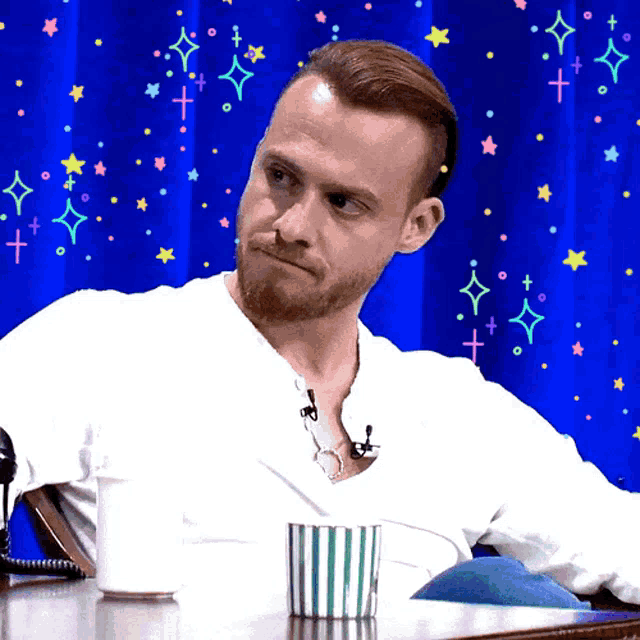 a man sits at a table with a cup of coffee
