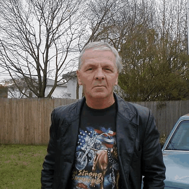 a man wearing a t-shirt that says ' all strong ' on it