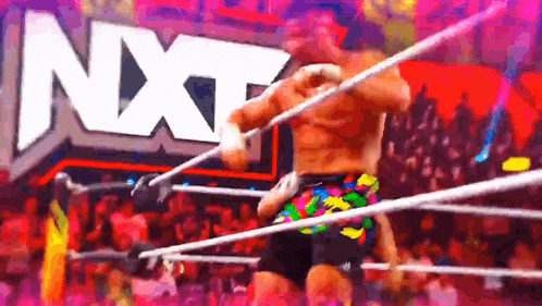 a man is wrestling in a ring with a nxt logo in the background