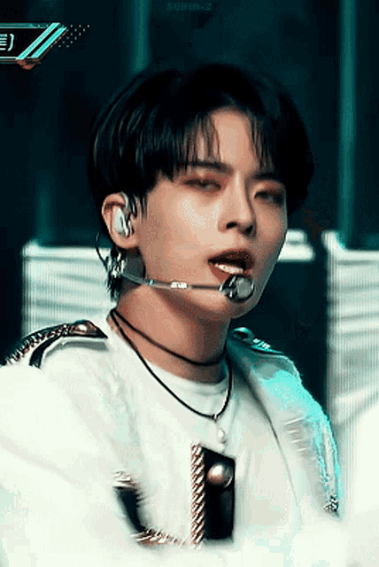 a close up of a person wearing a microphone and a necklace