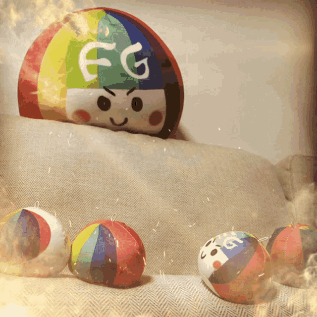 a rainbow pillow with the letters fg on it sits on a couch