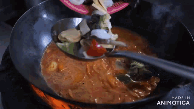 a spoon is being poured into a pot of food with the words made in animotica visible
