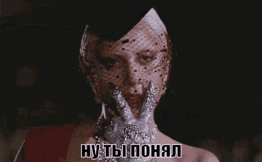 a woman in a veil and gloves is covering her face with her hands .