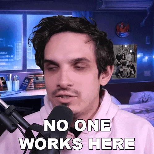 a man speaking into a microphone with the words " no one works here " below him