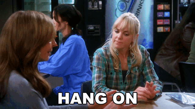 two women sitting at a table with the words hang on written on the bottom