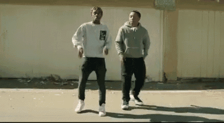 two men are standing next to each other on a sidewalk .
