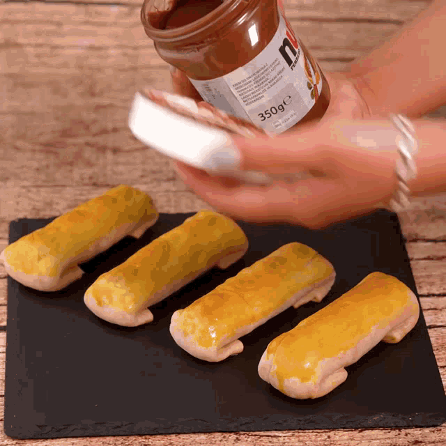 a jar of nutella is being poured on a tray of food
