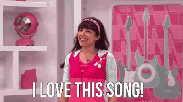 a girl in a pink outfit is smiling and saying " i love this song "