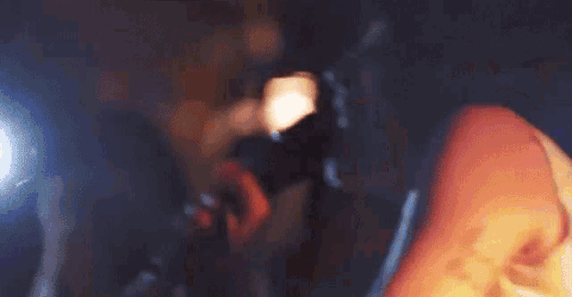a blurry picture of a person taking a picture of another person with a flashlight .