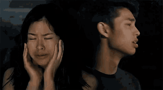 a man and a woman are crying in a dark room .