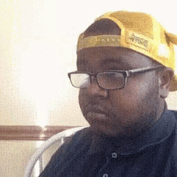 the man is wearing glasses and a yellow hat .