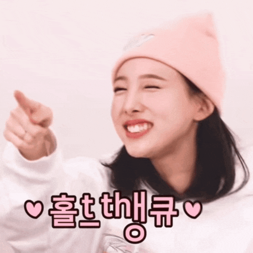 a woman wearing a pink hat and a white sweatshirt is pointing her finger