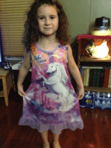 a little girl in a bella swan dress holds her dress up