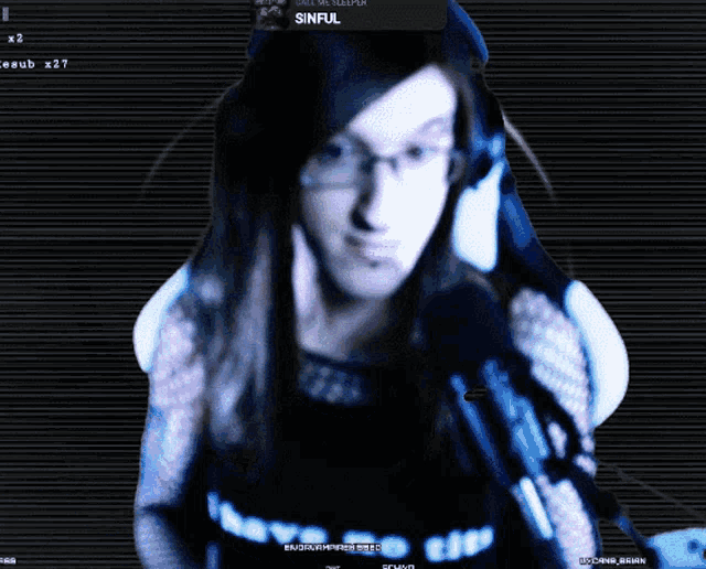 a computer screen shows a woman wearing headphones and a sinful notification