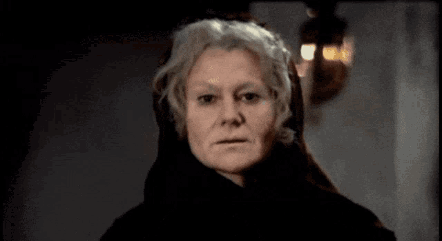a woman with gray hair is wearing a black scarf around her neck