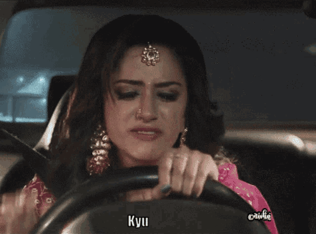 a woman crying while driving a car with the word kyu on the bottom