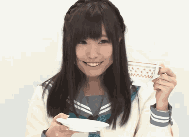 a girl in a school uniform is smiling while holding a cup