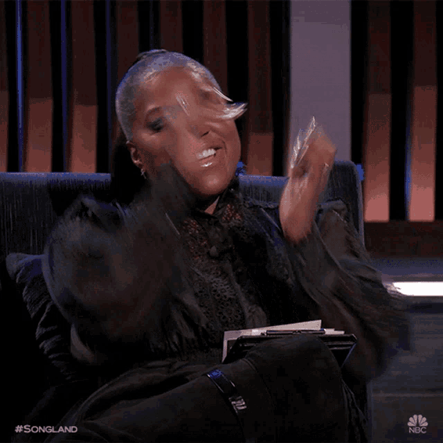 a woman is sitting in a chair with a nbc logo on the bottom right