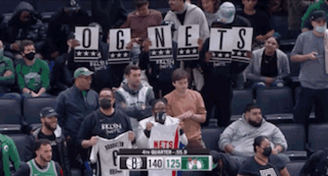 a crowd of people holding up signs that say o g nets