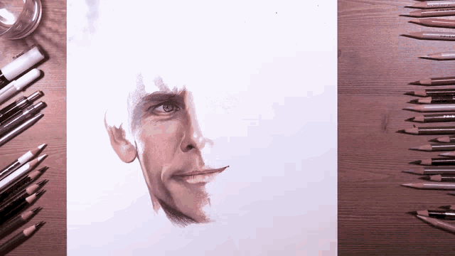 a drawing of a man 's face is on a table with colored pencils