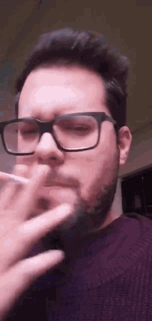 the man is wearing glasses and smoking a cigarette .