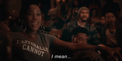 a woman wearing a t-shirt that says literally cannot is sitting in a crowd of people .