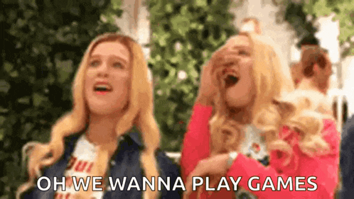 a couple of women are laughing and saying `` oh we wanna play games '' while standing next to each other .