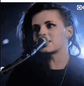 a close up of a woman singing into a microphone on a stage .