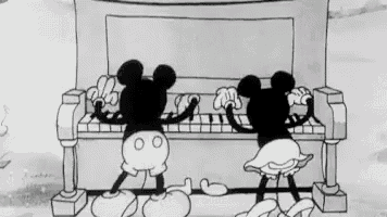 mickey mouse and minnie mouse are playing the piano in a black and white cartoon .