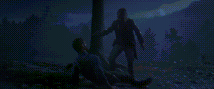a man is standing next to a man laying on the ground holding a lantern .