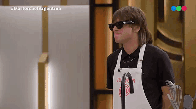 a man wearing sunglasses and an apron is on a television show called masterchef argentina