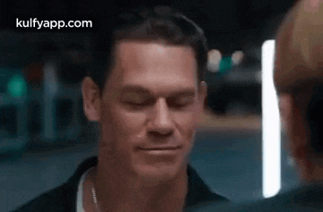 a close up of a man 's face with his eyes closed looking at another man .