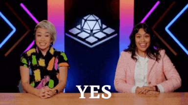 two women are sitting at a table with the word yes written on it