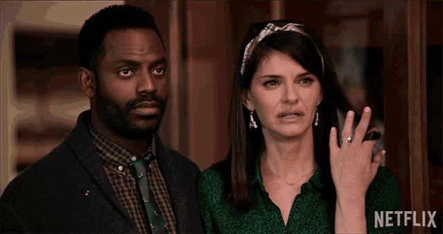a man and woman standing next to each other with a netflix logo on the bottom