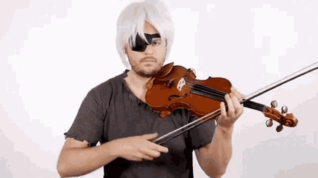 a man in a wig is playing a violin with a blindfold on his eye .