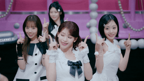 a group of girls in white dresses are pointing up at something