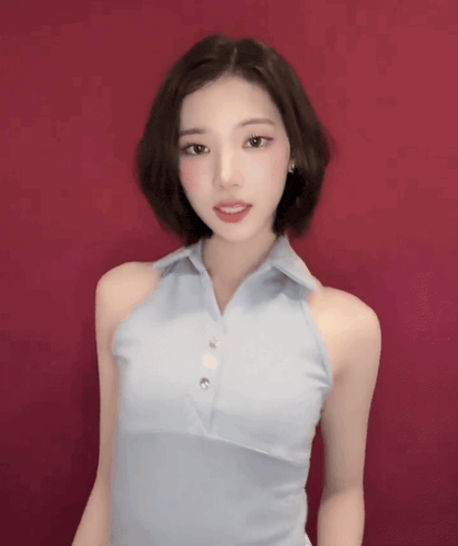 a woman in a blue halter top is standing in front of a red background .