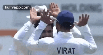 a group of cricket players are celebrating a wicket with their hands up .