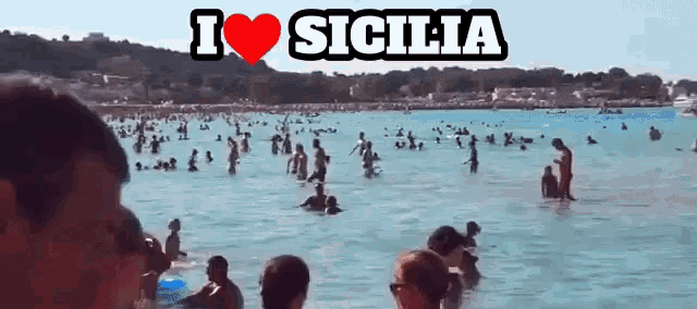 a group of people are swimming in the ocean with the words " i love sicilia " above them