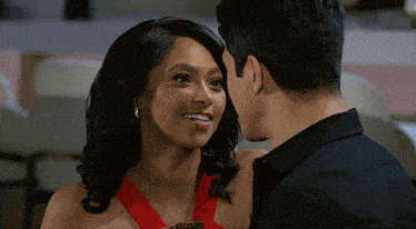 a man and woman are looking at each other and the woman is smiling