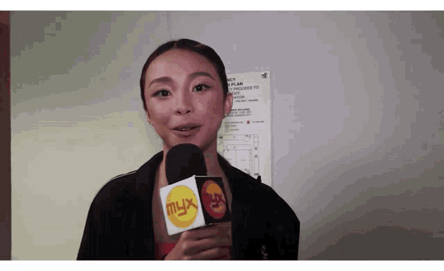 a woman is holding a microphone with the word myx on it