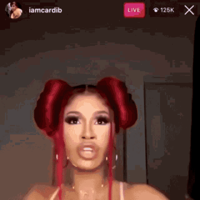 a woman with red hair is making a funny face while talking on a live stream .