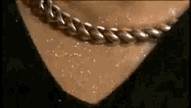 a close up of a person 's neck with a chain around it