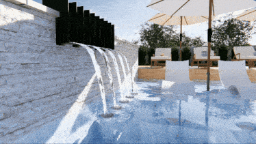 a swimming pool with umbrellas and chairs and a waterfall