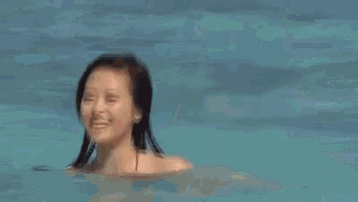 a woman in a red bikini is standing in a pool .
